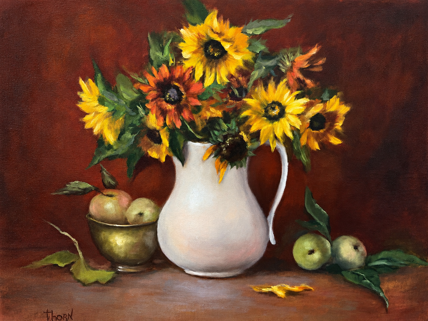 Yellow sunflowers in a white pitcher with apples on a brown tabletop